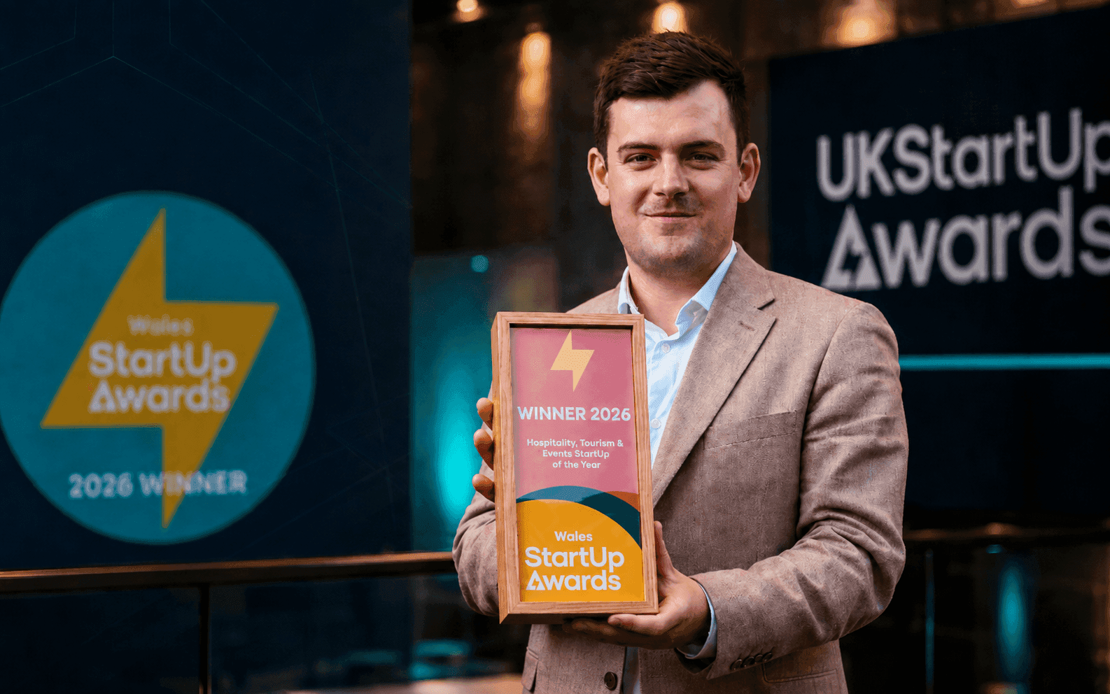 Dion Wright of Booking Hub holding the Wales StartUp Awards Winner 2026 trophy for Hospitality, Tourism & Events Startup of the Year.